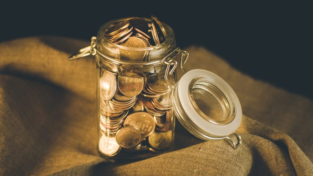 An open jar of coins on a cloth