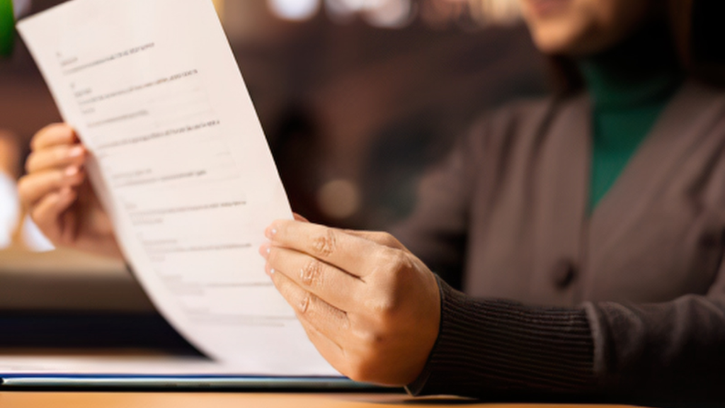 Person holding a letter at a desk